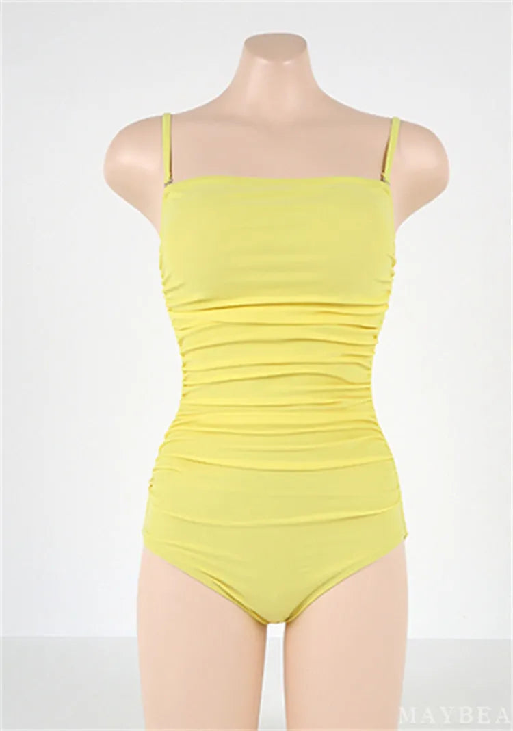 Blue sling style one-piece swimsuit with belly pleating on a model