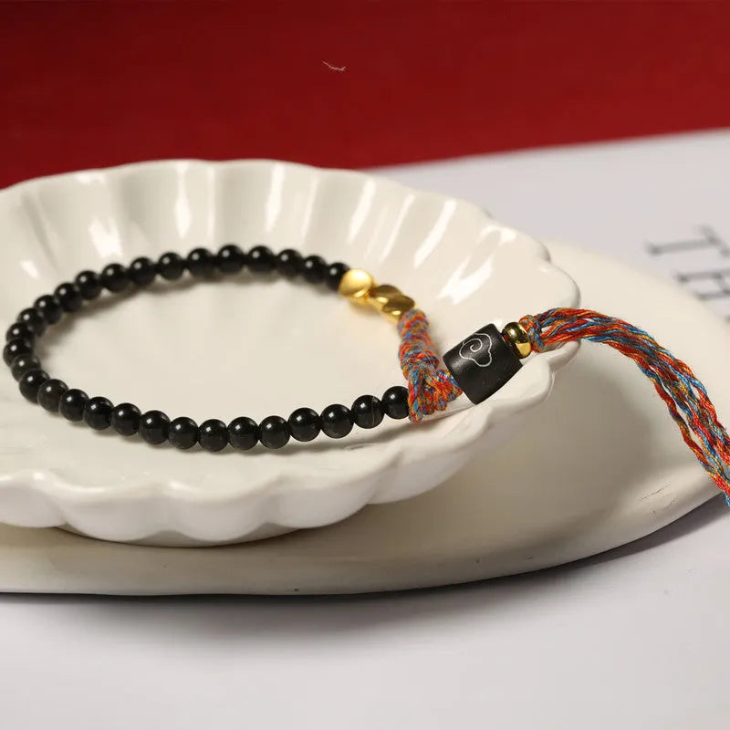 Hand-woven obsidian carrying strap bracelet showing textured surface and adjustable 15.5-16cm length