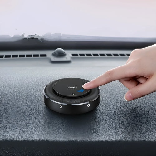 Round black aluminium alloy Bess car fragrance unit placed on a car seat.
