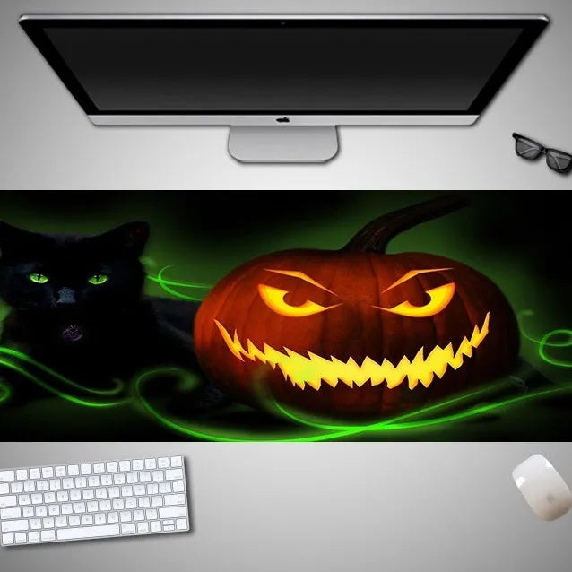 Large Halloween patterned gaming mouse pad on a desk showing non-slip rubber base and extra-long design.