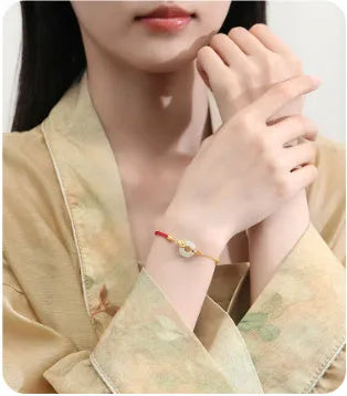Gold-colour Koi fish charm bracelet in 925 silver with a red rope and peace buckle safety clasp.