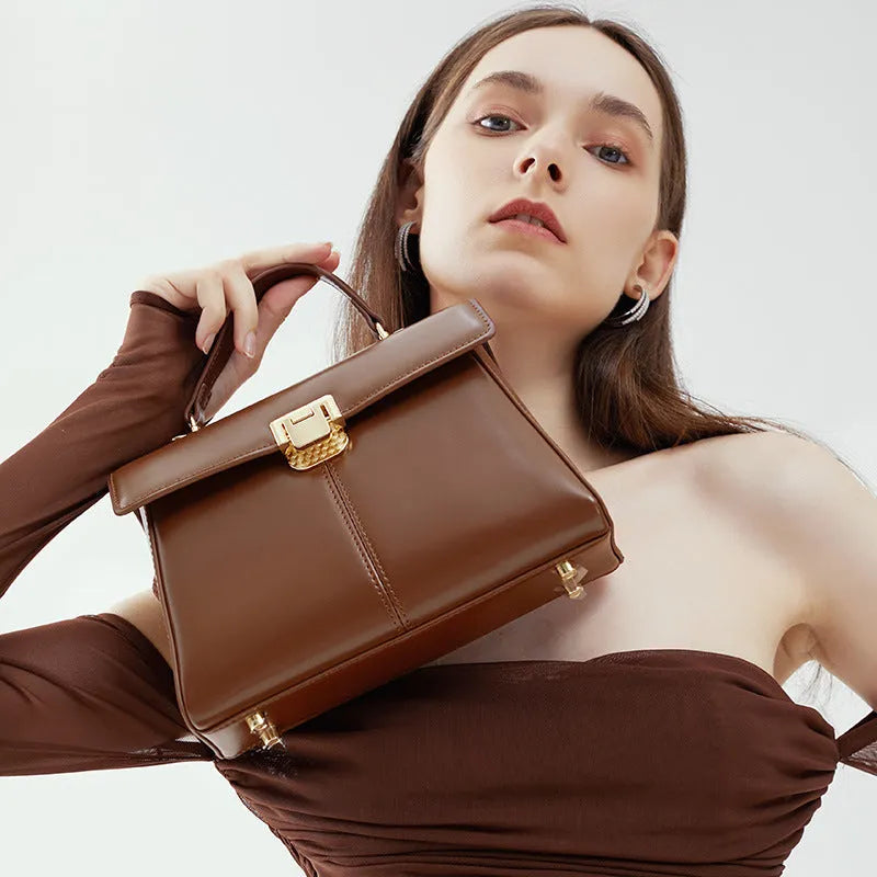 Genuine leather women's clasp shoulder bag in black, showing horizontal square shape and strap.