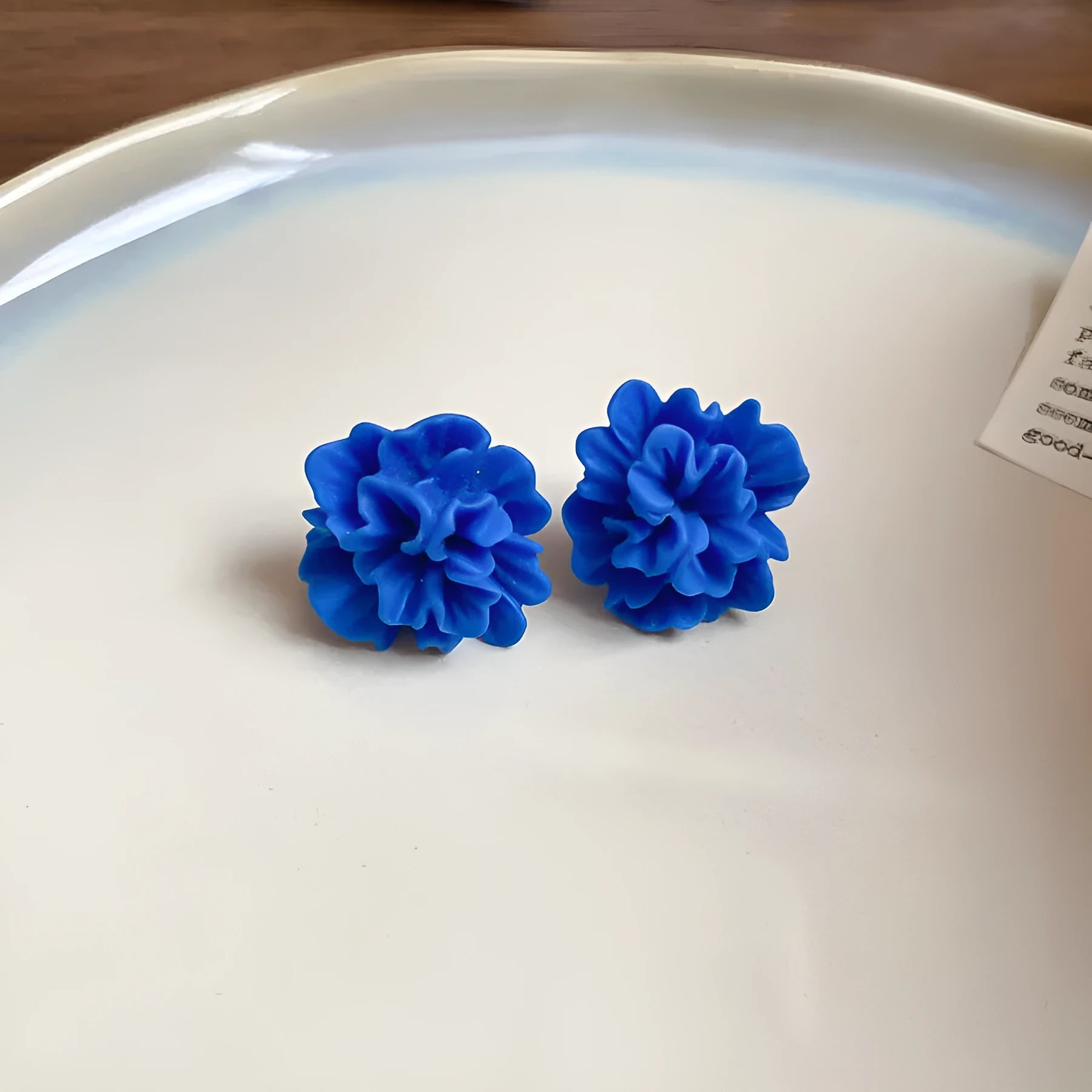 Women's geometric earrings with blue resin flower on textile base, circular shape