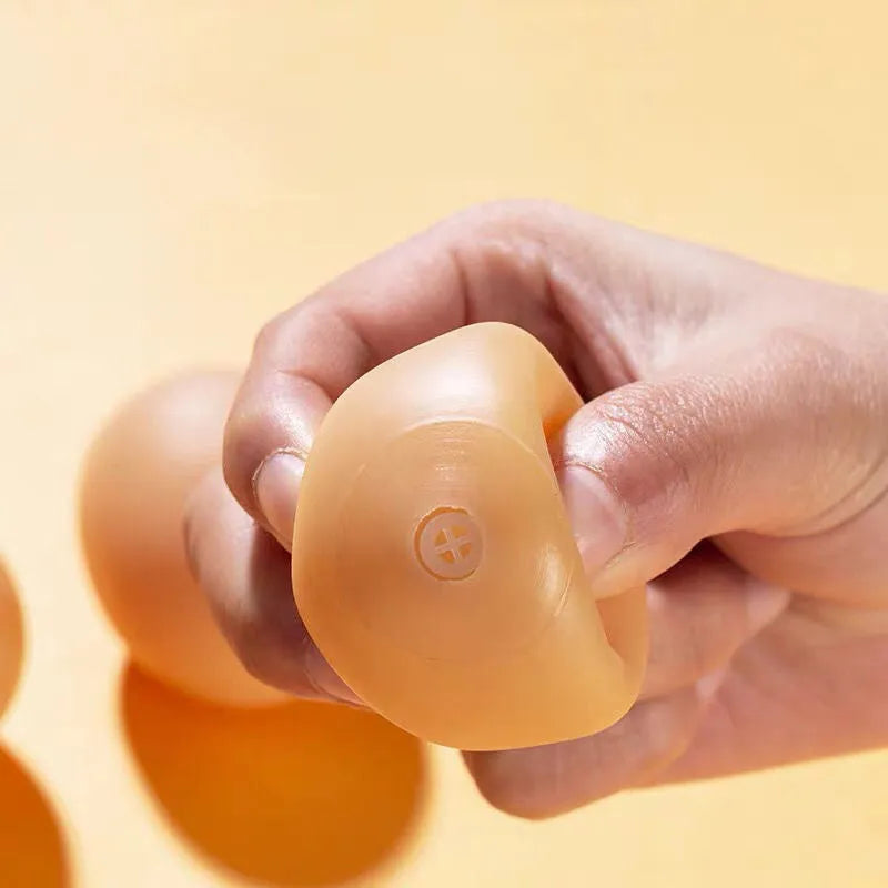 Red rubber egg-shaped dog chew toy with squeaker sound mechanism for dental care and interactive play.