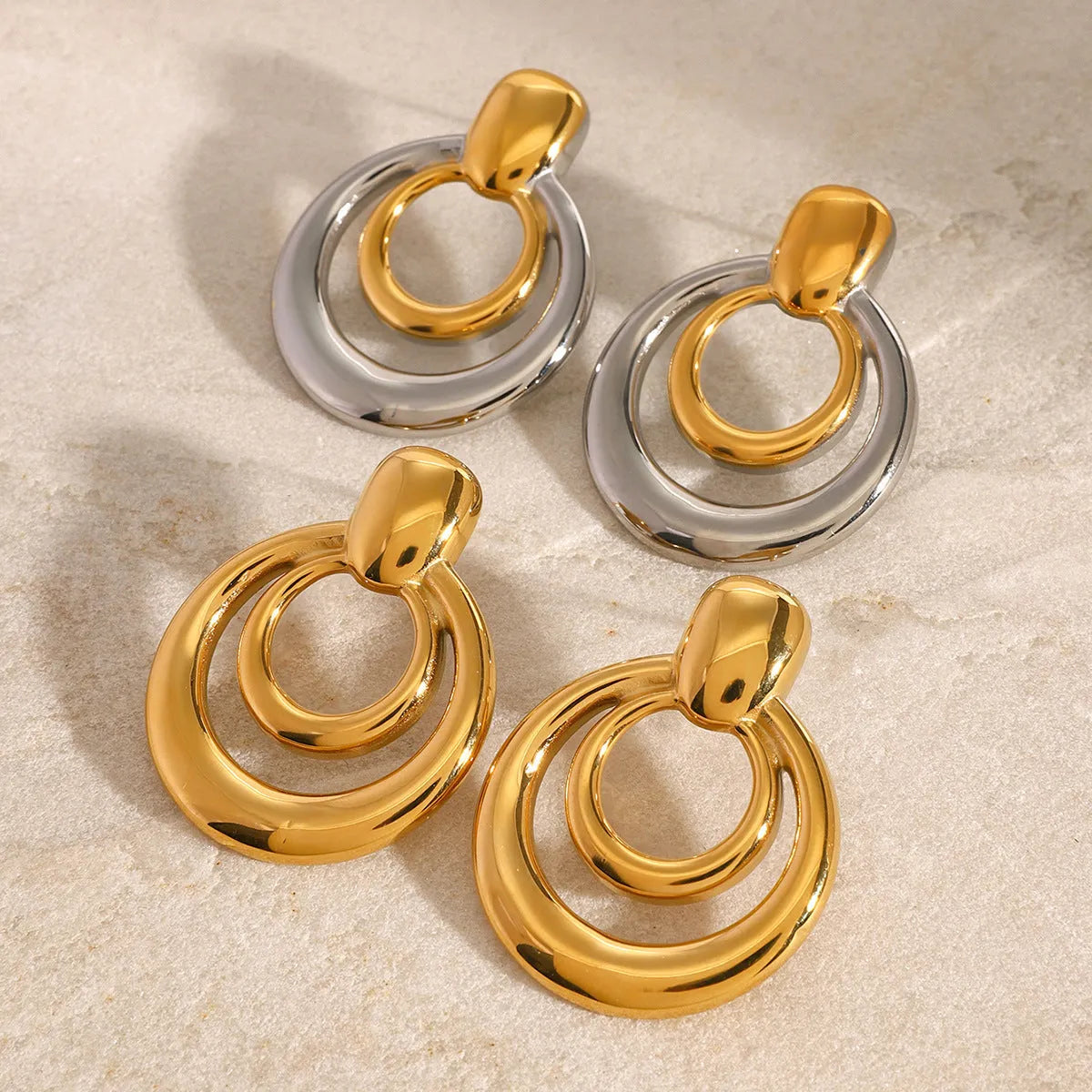 Golden titanium steel stud earrings with double-layer hollow design and round geometry shape