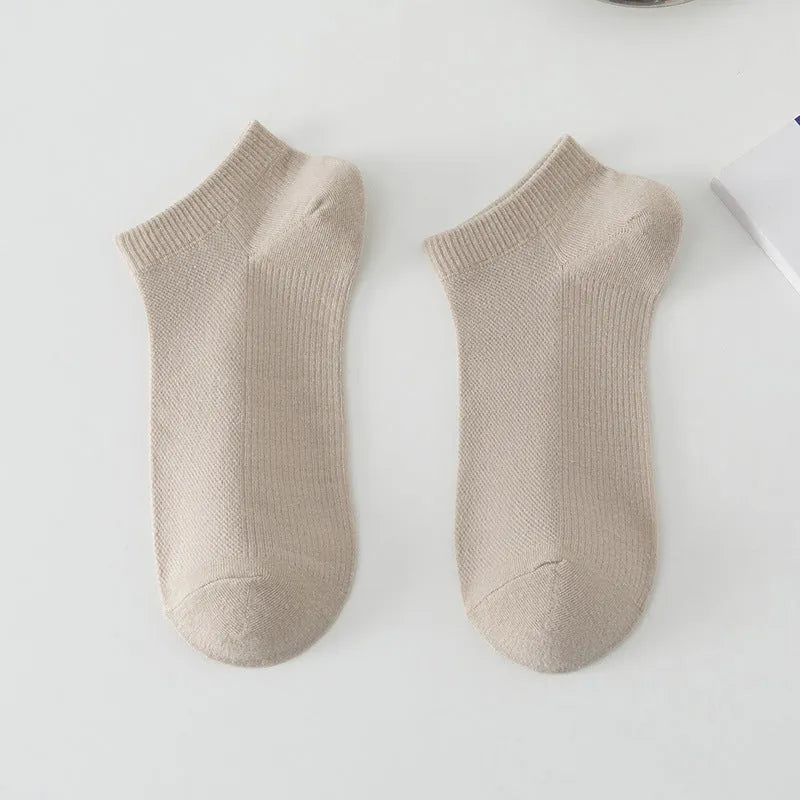 A pair of solid colour low-cut men's boat socks made from breathable polyester fabric.