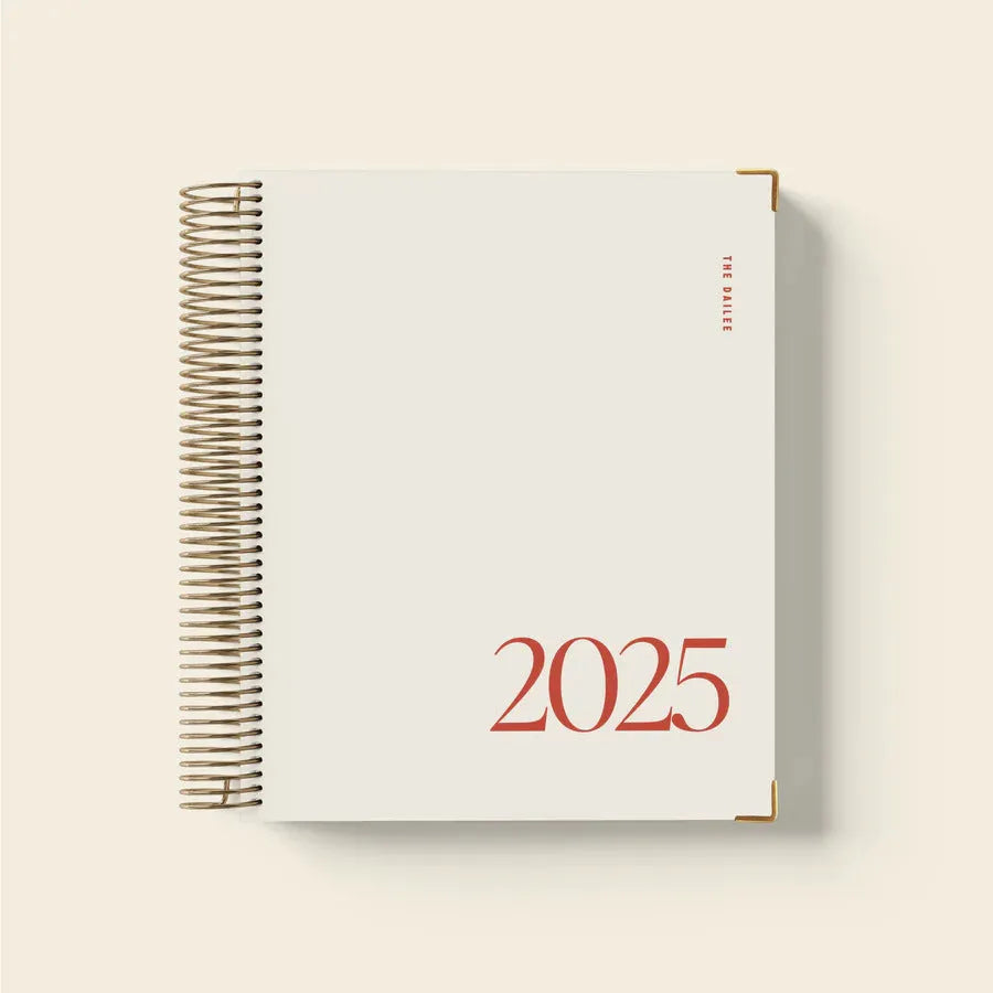 Cherry red A4 spiral coil notebook open on a desk, showing flat-lying pages.