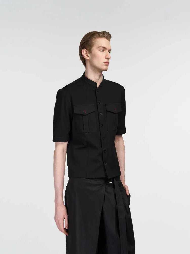 A black loose fit half sleeve hunting shirt with a shirt collar on a hanger.