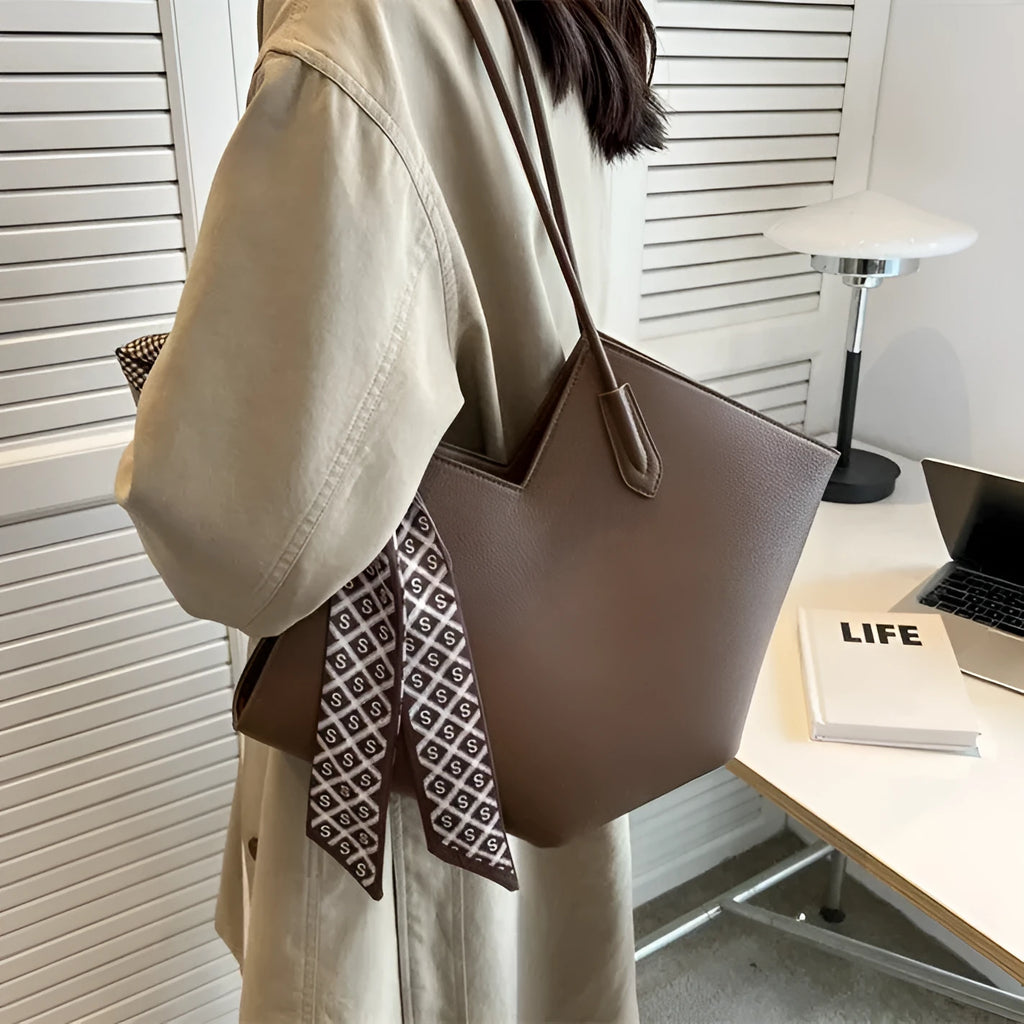 Women's large beige PU leather shoulder bag with top handle showing structured horizontal square shape.