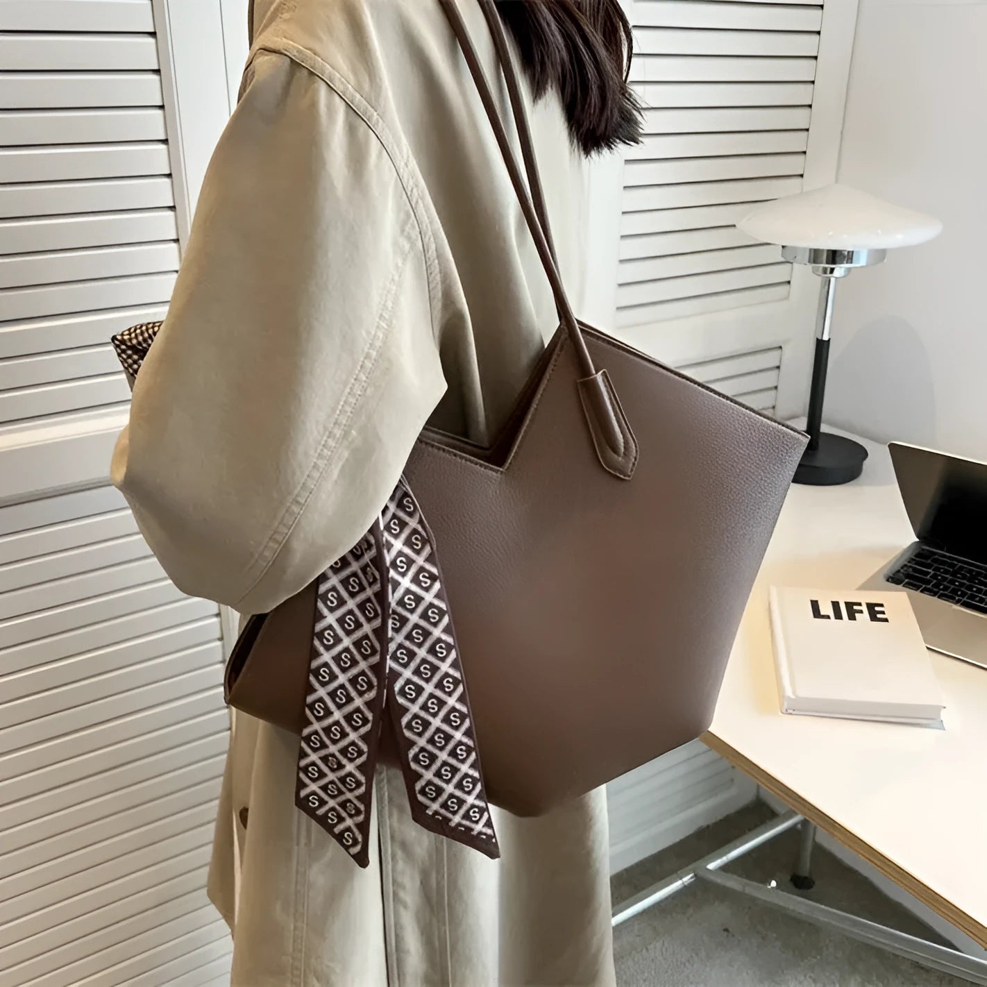Women's large beige PU leather shoulder bag with top handle showing structured horizontal square shape.