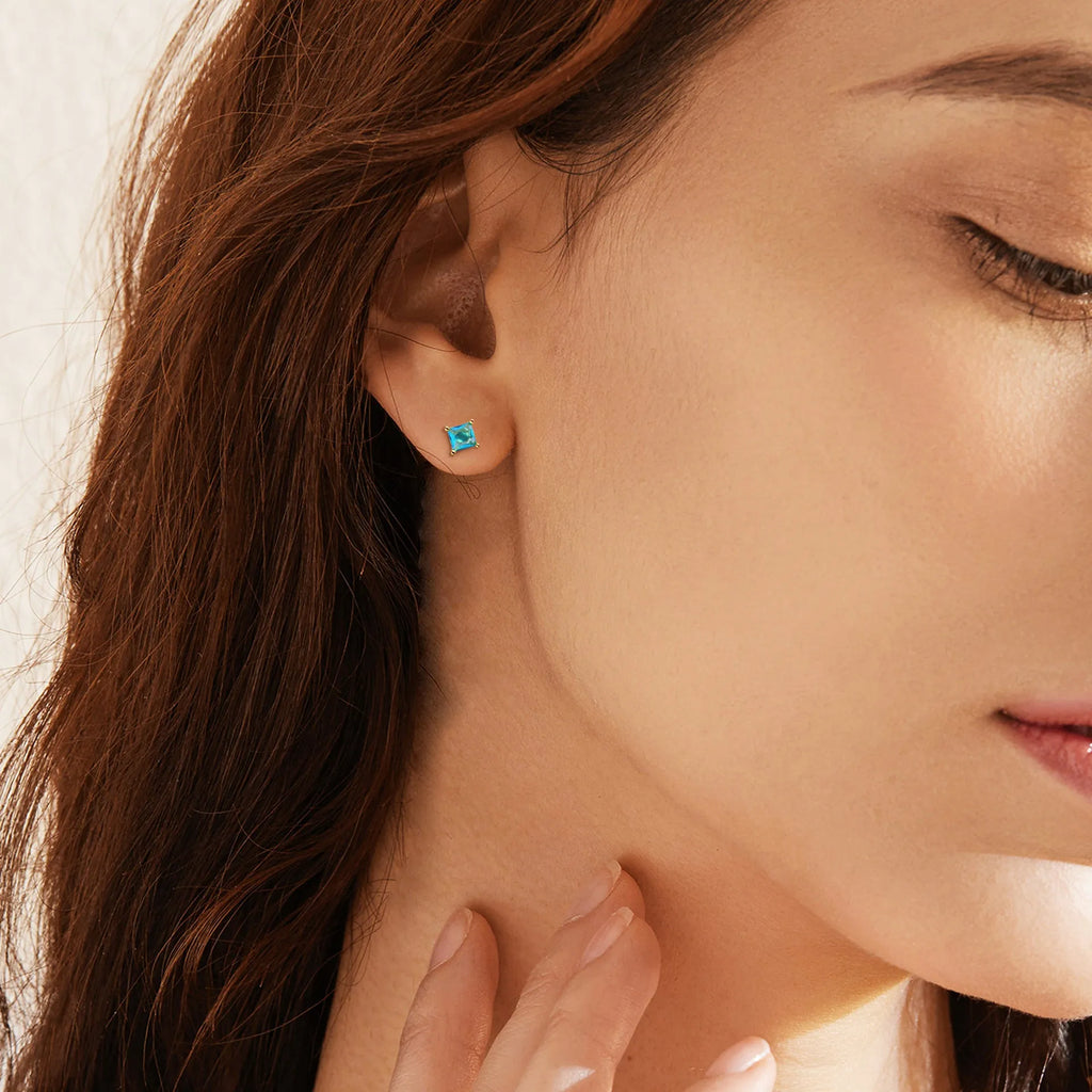 A pair of brass gold-plated drop earrings with a candy-coloured pear-shaped zircon stone.
