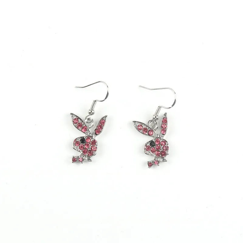 Close-up of rabbit-shaped stud earrings with sparkling cubic zirconia stones in gold, pink, and silver finishes.