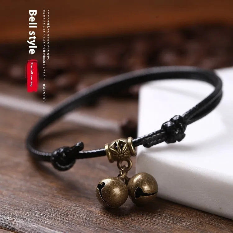 A nylon rope dog collar with a brass buckle shown alongside a version with a brass bell, in black, red, and coffee colours.
