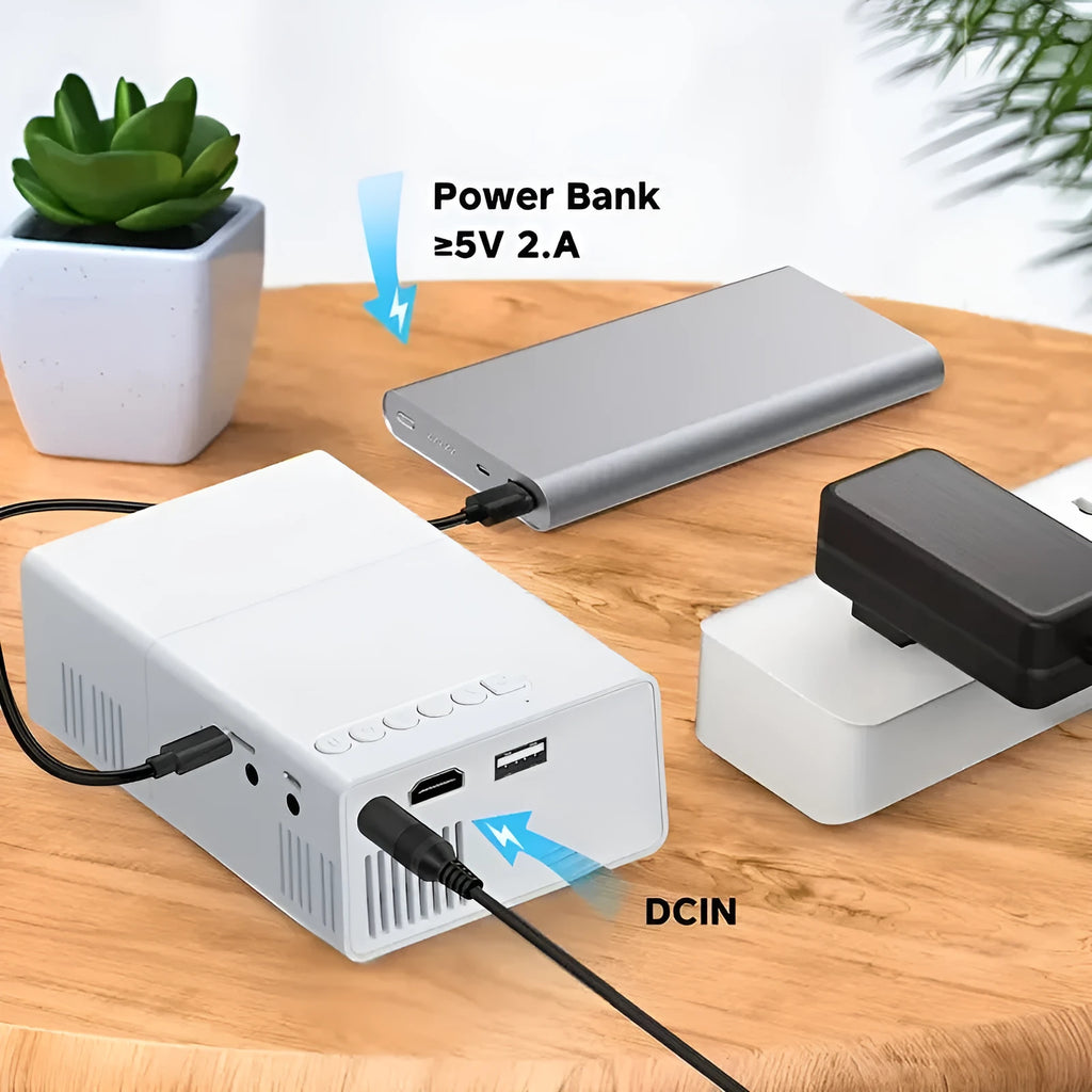 White or black M100 mini portable home projector with remote control on a table.
