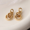 Gold geometric drop earrings with irregular design elements on copper base