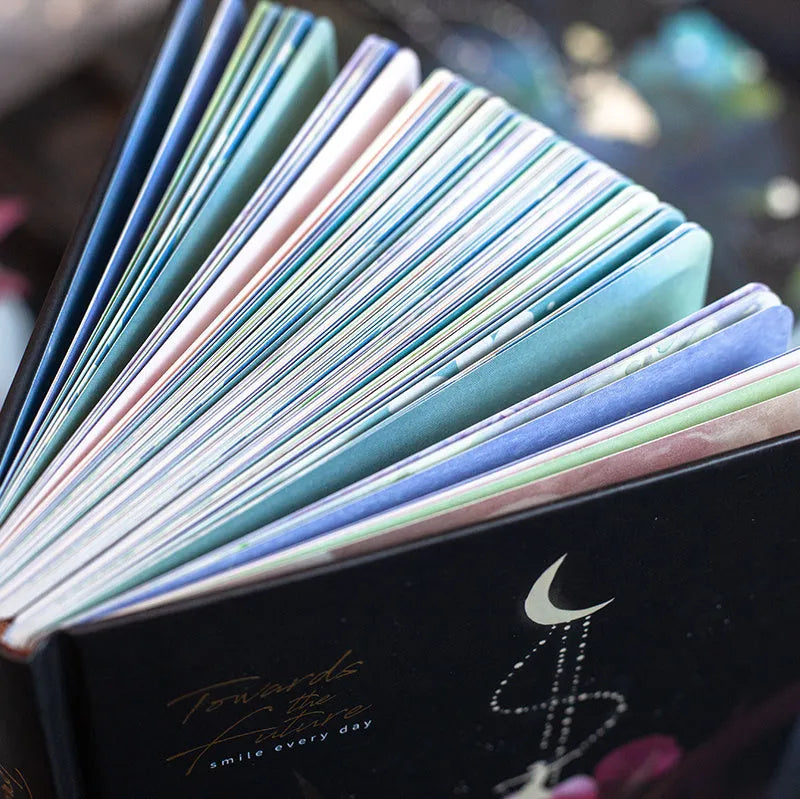 A5 notebook with luminous reflective cover open to show pages with colourful illustrated backgrounds.