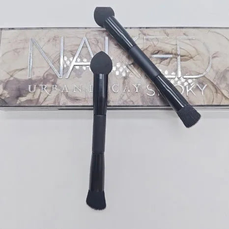 Double-headed concealer brush with black wooden handle, artificial fibre bristles, and angled sponge tip.