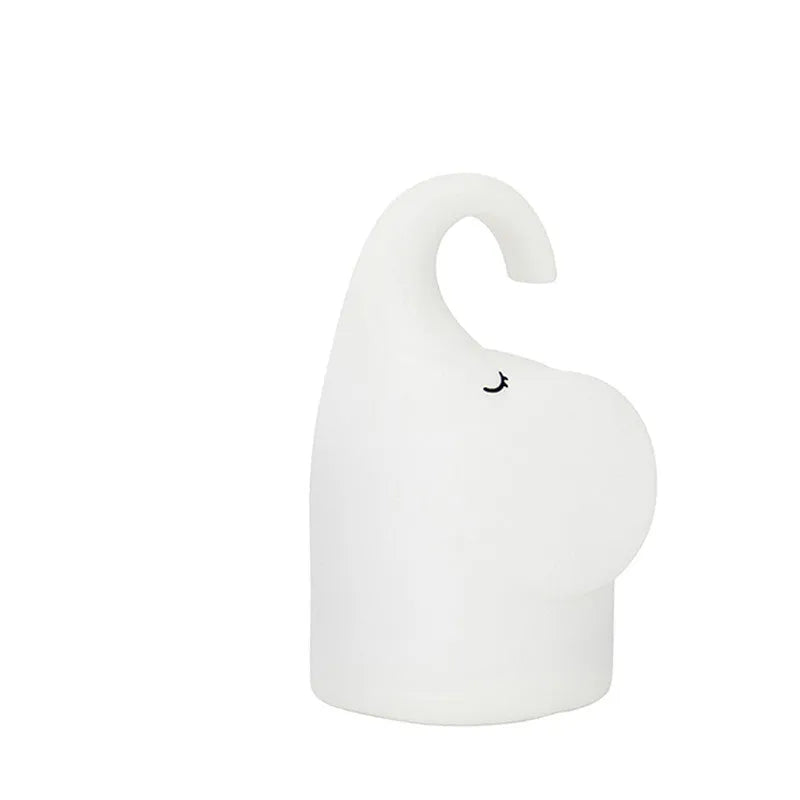 DOMI Elephant shaped silicone night light on a table showing its compact size and soft glow.