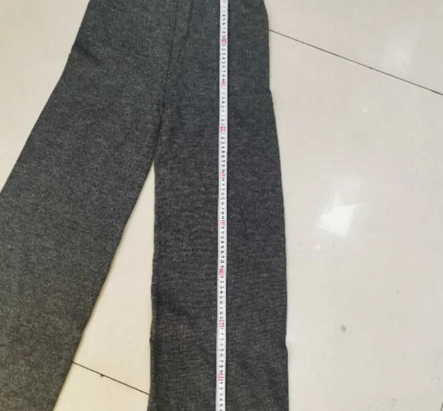 Women's dark grey acrylic knitted lounge suit with side-slit sweater and matching trousers on a hanger.