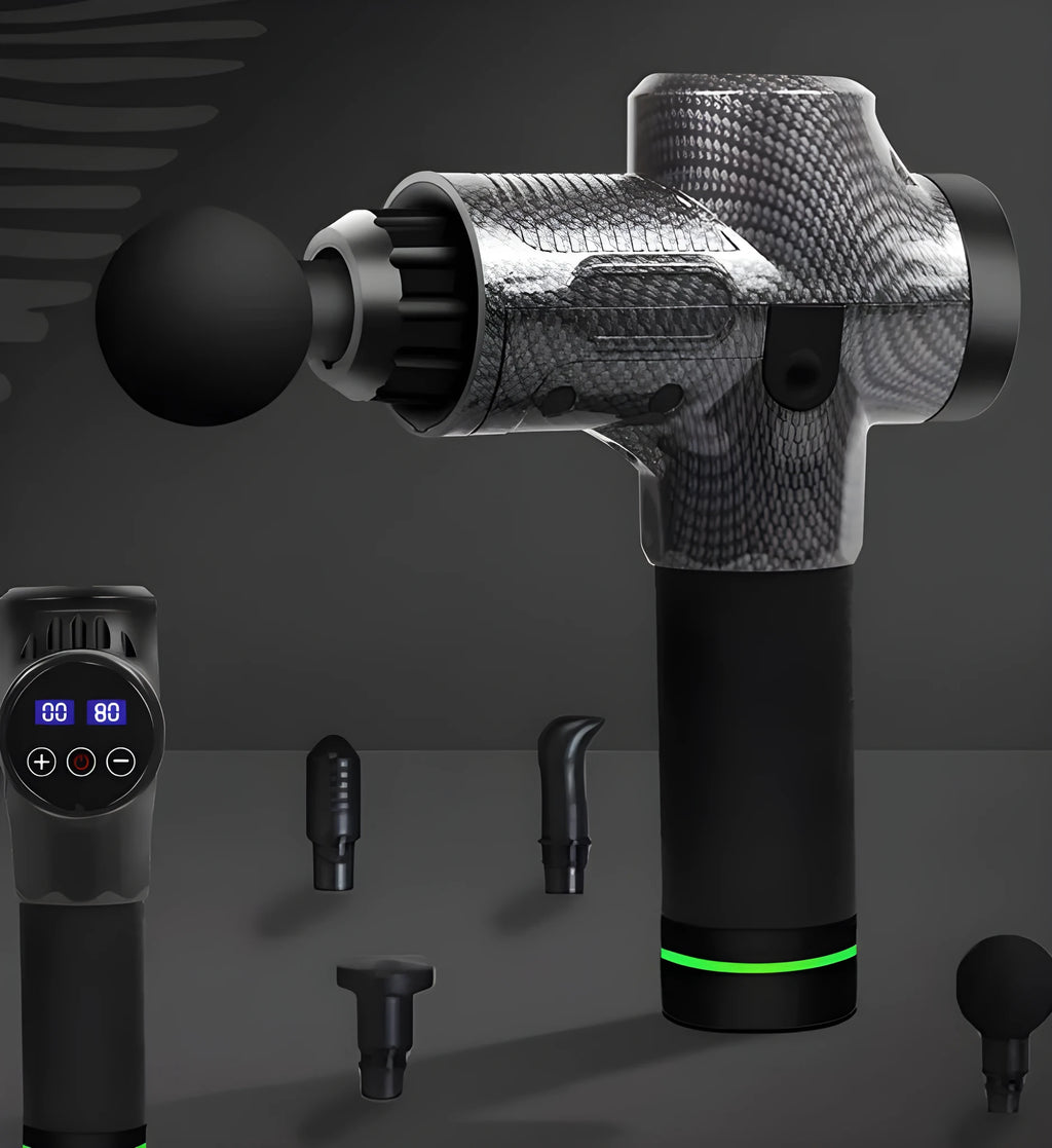 Black electric muscle massage gun with multiple attachment heads on a table.