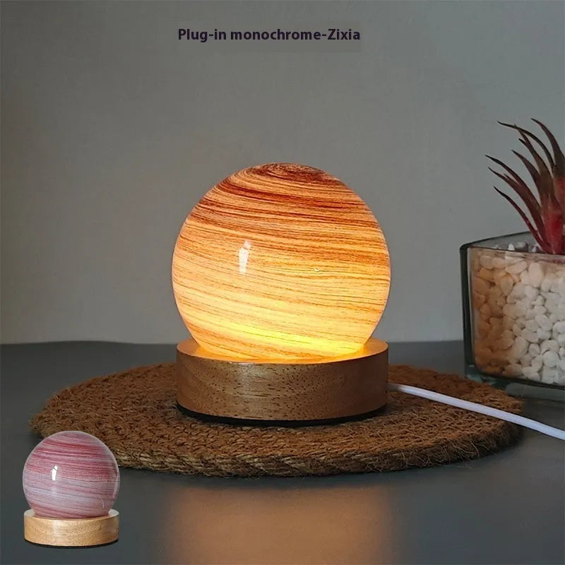 Modern planet-shaped USB night light with dimming on a desk.