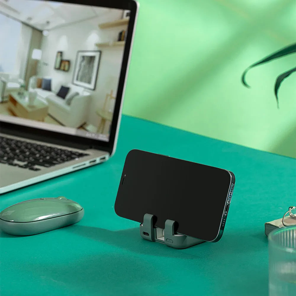 Multi-function bracket mobile power supply in red, green, or purple showing dual charging ports and integrated phone stand.