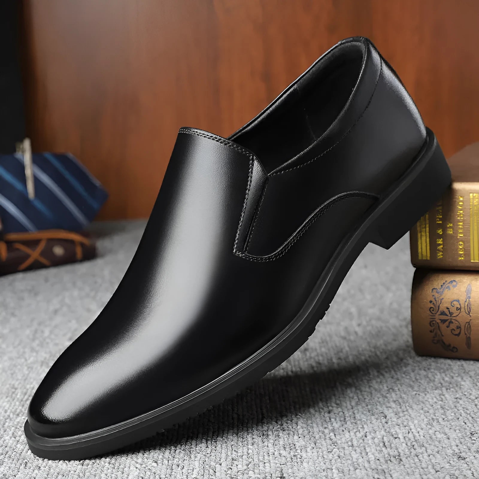 Men's black low-top slip-on leather shoes with a rubber sole and sewing line detailing.