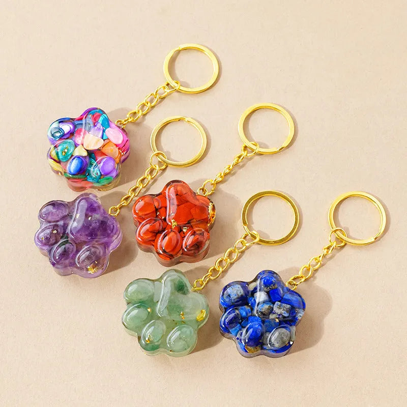 Hand-finished natural crystal cat's paw keychain pendant on a metal ring, showing detailed carving and polished stone surface.