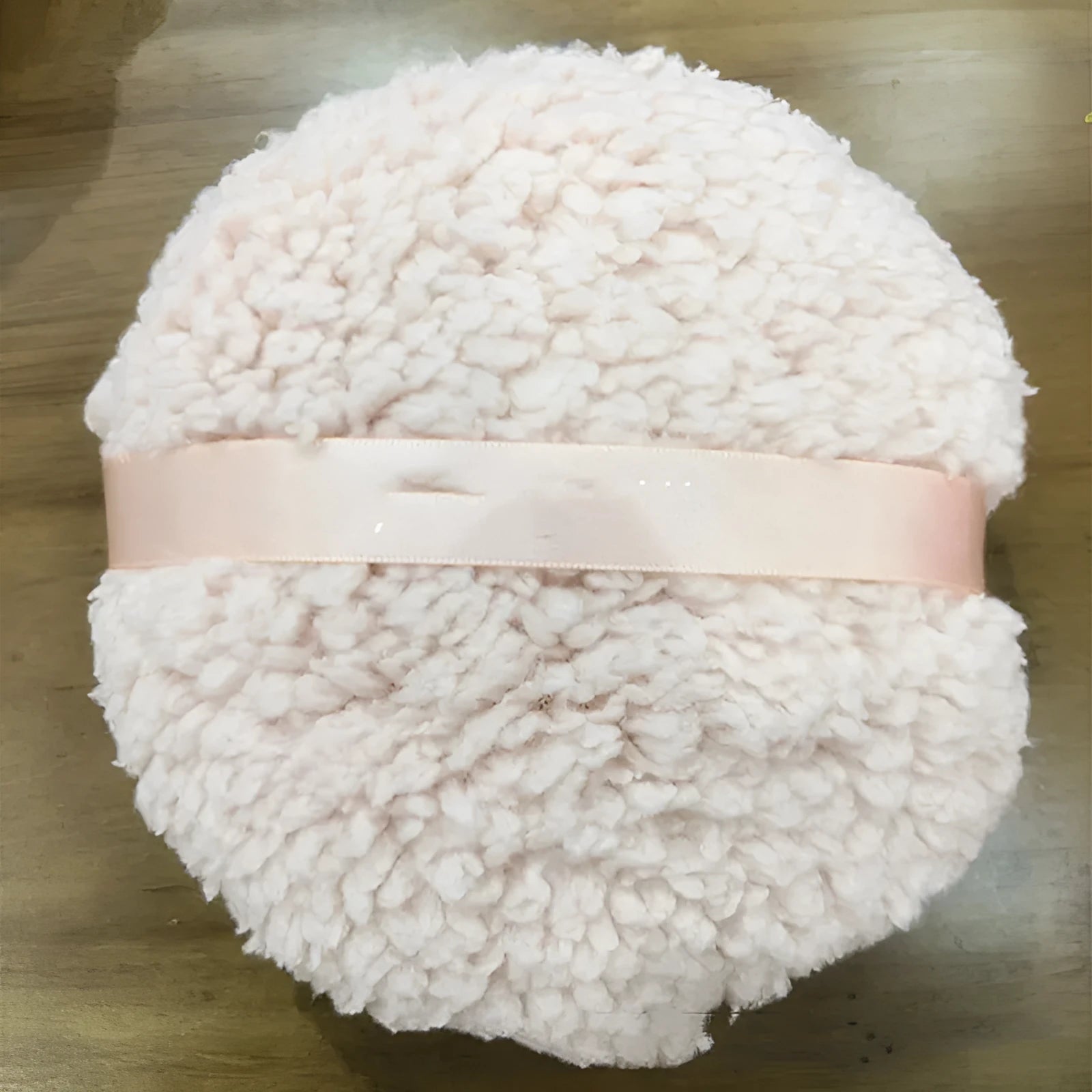 Large rectangular plush powder puff for makeup application in pink, white, or skin colour.
