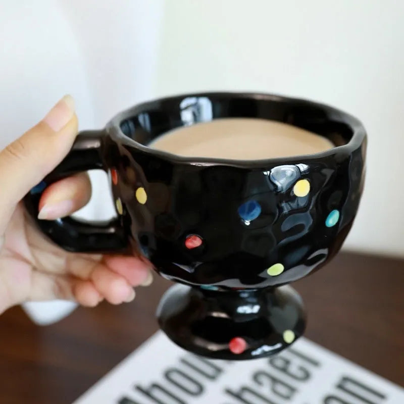 Handmade irregular solid colour ceramic mug on a table, showing its unique shape.