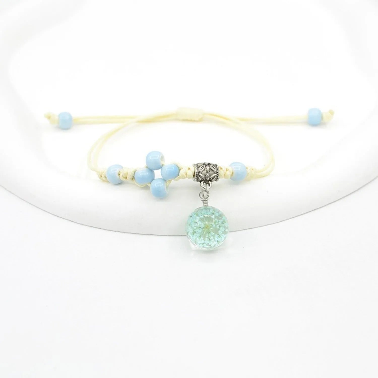 Hand-woven glass bracelet with large beads containing real dried flowers, shown in multiple colour options.