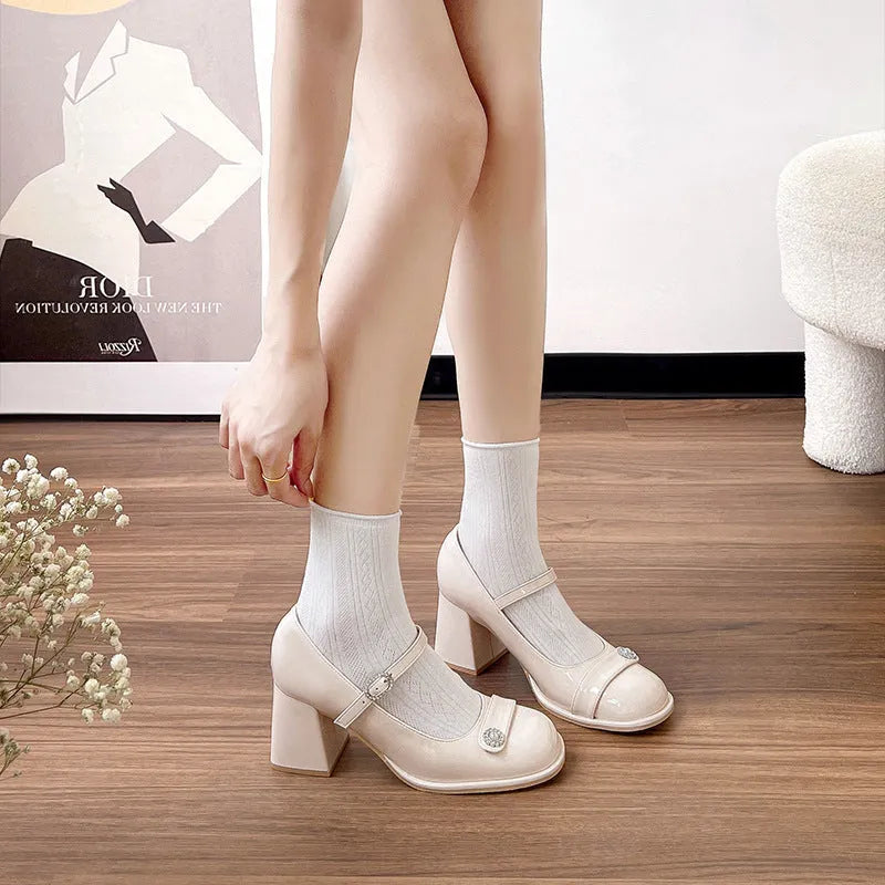 Women's black patent leather wide fit chunky heel shoe with round toe and buckle fastening.