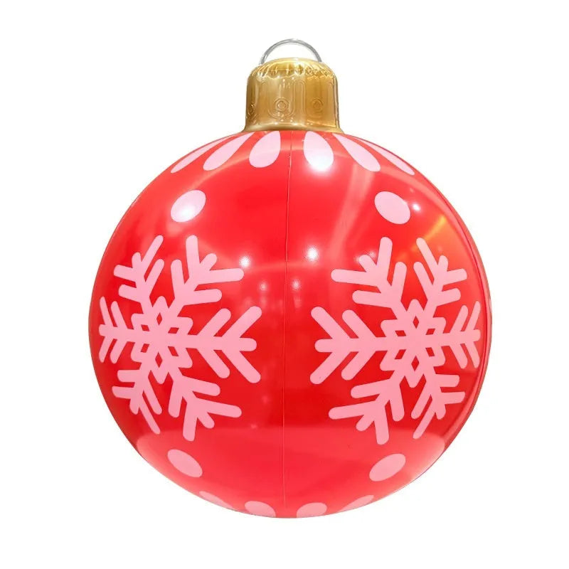 Large red and white inflatable Christmas ball with flashing lights in a garden setting