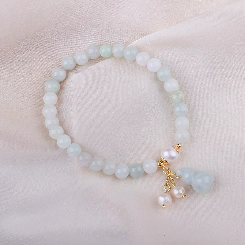 Traditional Chinese style jade bracelet with raised gourd design and pearl accents on green stone