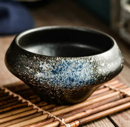 Tall porcelain ceramic Japanese soup bowl with underglaze vintage pattern on wooden table.
