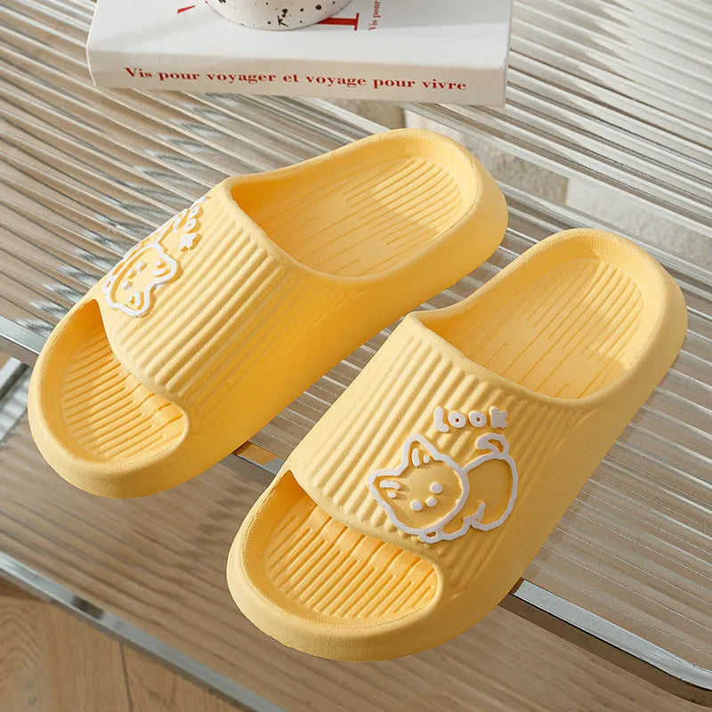 Women's pink EVA cat slippers with thick platform sole on a wooden floor.