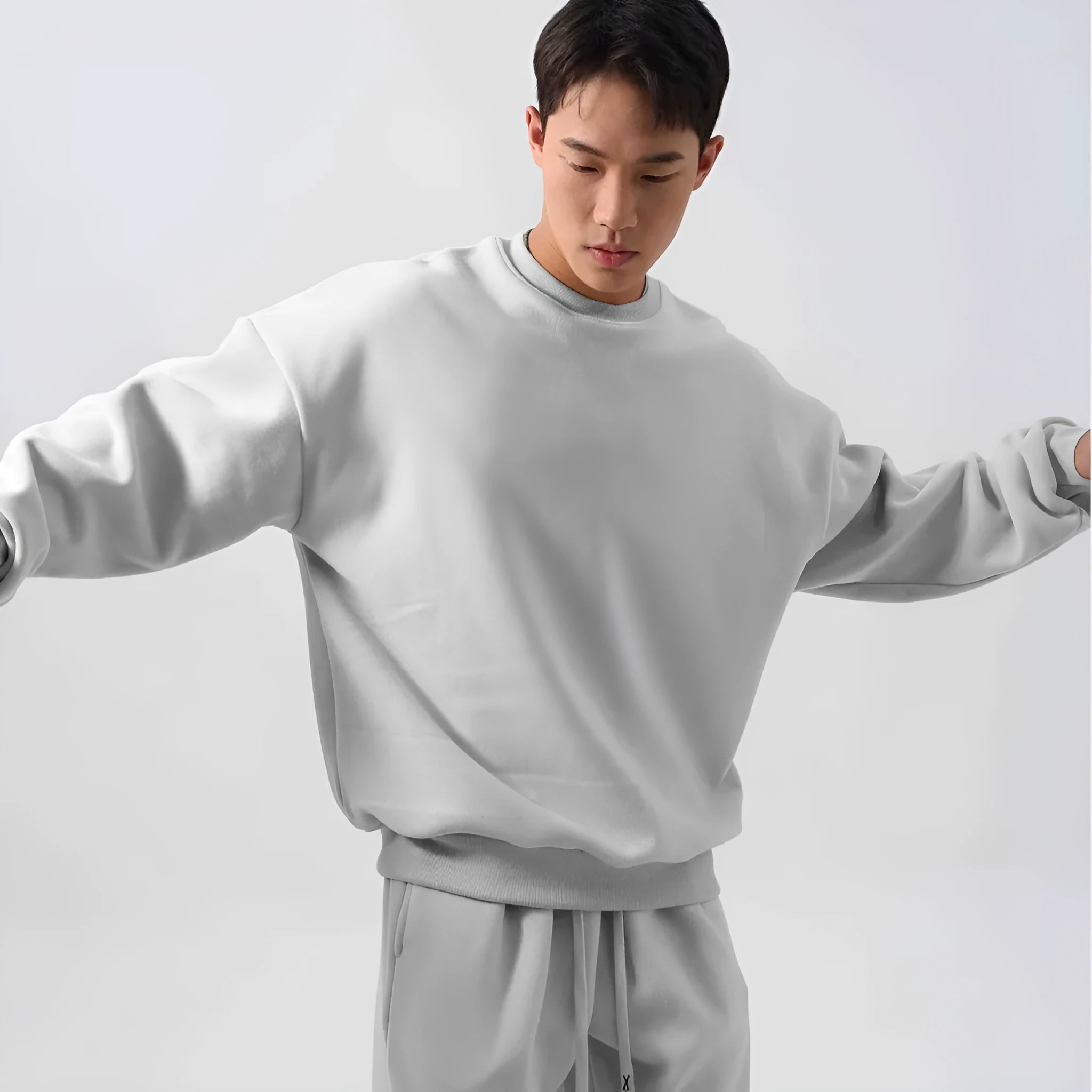Man wearing a loose black polar fleece winter sports suit with crew neck coat and trousers