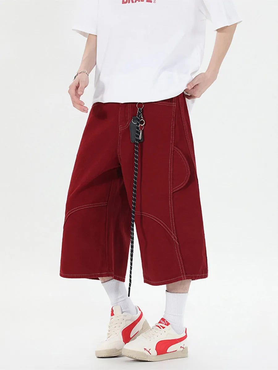 Red and black denim workwear shorts with multiple pockets, cropped length, and wide leg design