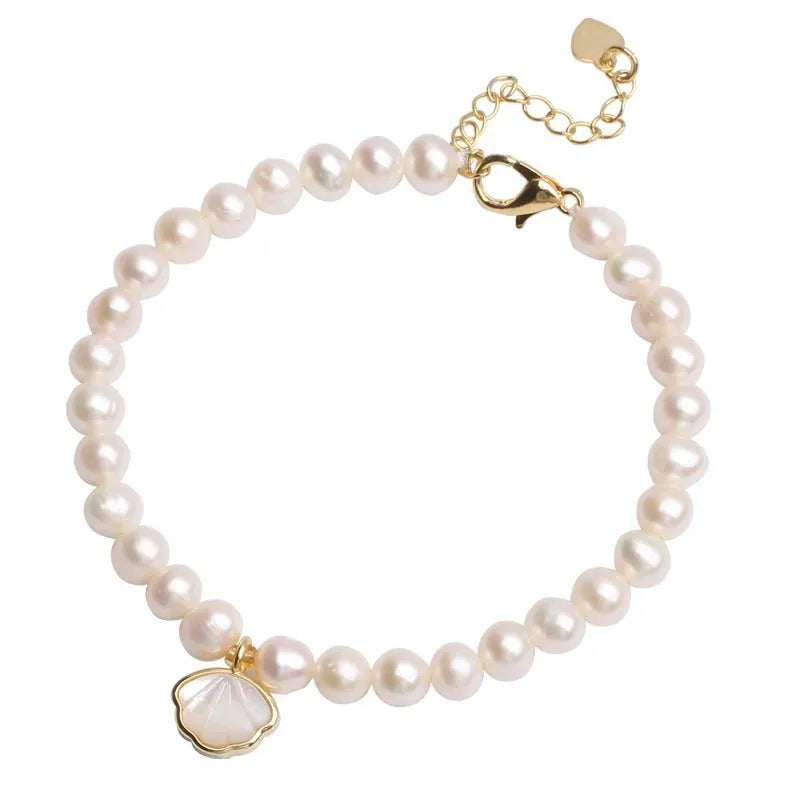 A women's freshwater pearl bracelet with a fan-shaped shell clasp, shown in both elastic and extension chain fastening styles.