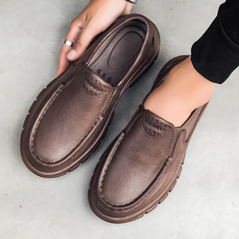 Men's black and brown slip-on work shoes with a waterproof platform and mid-top design.