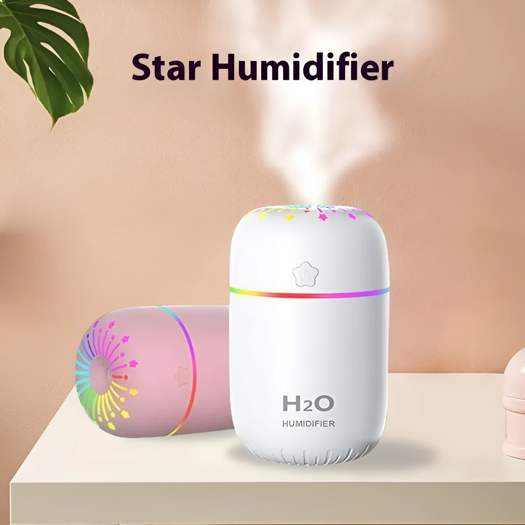 Compact white USB-powered mini humidifier with water tank on a wooden desk.
