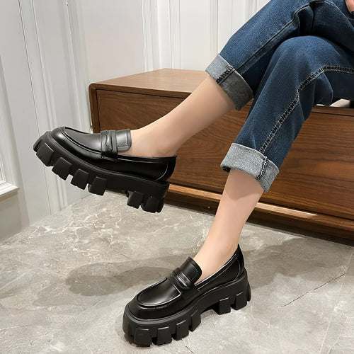 British style wide-fit patent leather loafers with a distinctive muffin heel on a rubber sole.