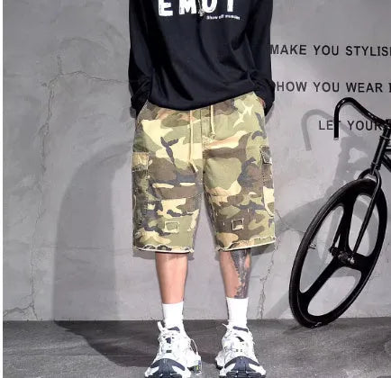 Man wearing loose, cropped camouflage shorts in a khaki colourway, showcasing the summer workwear style.