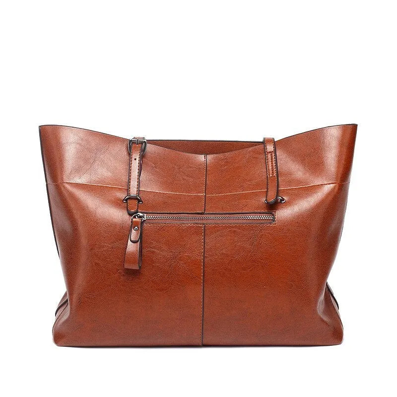 Brown waxed cowhide cross-body handbag showing front flap and adjustable shoulder strap.
