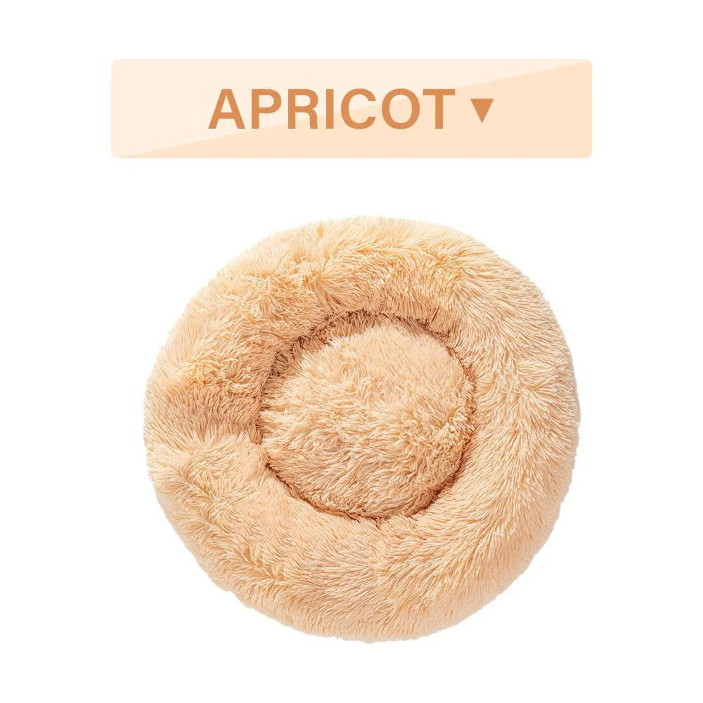 Fluffy grey donut-shaped dog bed with high plush sides on a wooden floor.