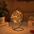 Round glass wish bottle with cork, 12 cm diameter, containing a warm white LED light strand with 20 lamp beads and folded paper stars