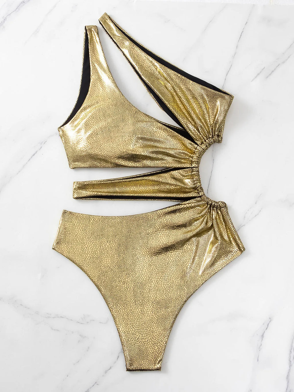 Gold women's one-piece swimsuit with a backless design on a mannequin.