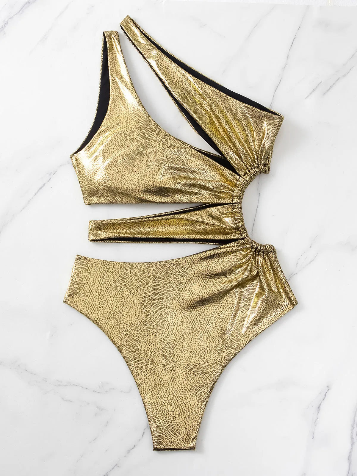 Gold women's one-piece swimsuit with a backless design on a mannequin.