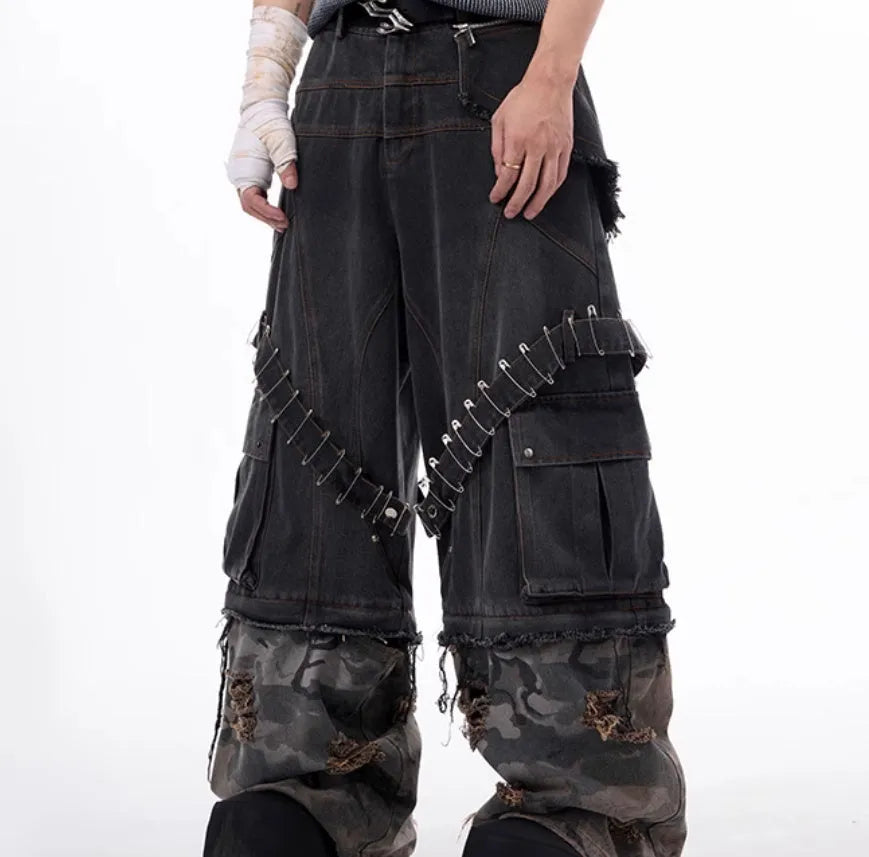 Men's grey jeans with camouflage splicing design and pin and ribbon details on the legs.