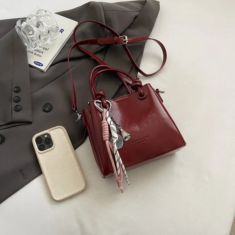 Women's medium-soft PU messenger bag in bucket shape with pendant, black, white, wine red, and pink options